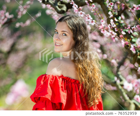 Happy girl in the spring garden peach in red dress 76352959