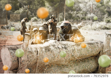 Paintball players playing outdoors 76352978