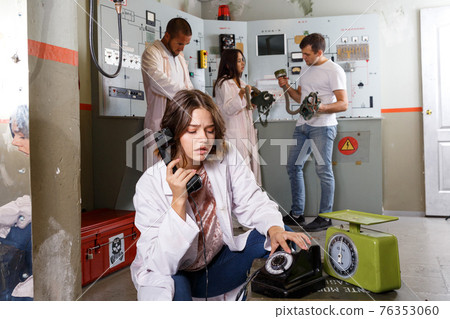 Girl using telephone set in escape room 76353060