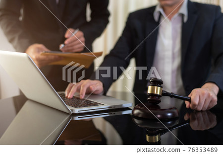 Lawyer businessman and two business partners working together in office. Businessmen sitting at desk and making notes. Lawyer businessman and two business partners working together in office. Businessmen sitting at desk and making notes. 76353489