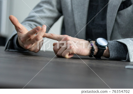 partial view of businessman with hands in lock sitting at table, business concept 76354702