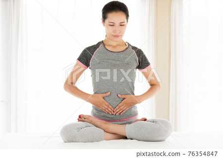 A woman holding her tummy A woman holding her tummy 76354847