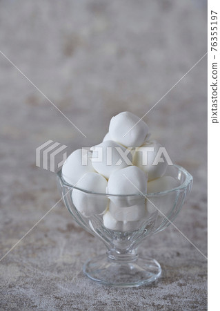 Vanilla-flavored marshmallows in a glass bowl 76355197