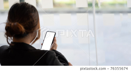 Close up business woman using smart phone with white blank screen at office Close up business woman using smart phone with white blank screen at office 76355674