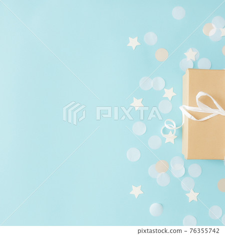 Paper gift box tied with ribbon, star and circle paper confetti or glitters Paper gift box tied with ribbon, star and circle paper confetti or glitters 76355742
