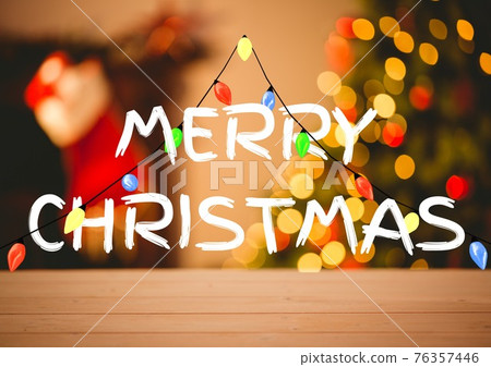 Merry christmas text with fairy lights and out of focus christmas tree and stocking in background Merry christmas text with fairy lights and out of focus christmas tree and stocking in background 76357446