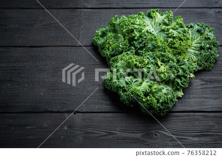 Fresh organic green kale leaves, on black wooden table background , with copyspace and space for text Fresh organic green kale leaves, on black wooden table background , with copyspace and space for text 76358212