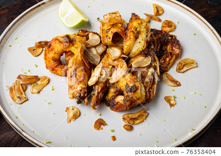 Large grilled BBQ shrimp with sweet Mango sauce and curry, on plate, on old dark wooden table background Large grilled BBQ shrimp with sweet Mango sauce and curry, on plate, on old dark wooden table background 76358404