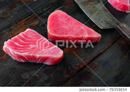 Raw organic tuna fillet. Seafood, and old butcher cleaver knife, on old dark wooden table background 76358654