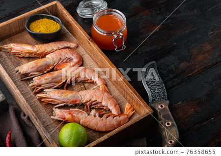 Raw red Argentinian prawns, in wooden box, on old dark wooden table background , with copyspace and space for text 76358655