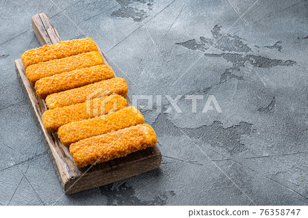 Frozen fish sticks. Organic fish food, on wooden cutting board, on gray background , with copyspace and space for text 76358747