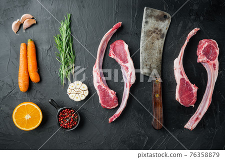 Frenched raw fatty lamb chops, with ingredients carrot orange, herbs, on black stone background, top view flat lay Frenched raw fatty lamb chops, with ingredients carrot orange, herbs, on black stone background, top view flat lay 76358879
