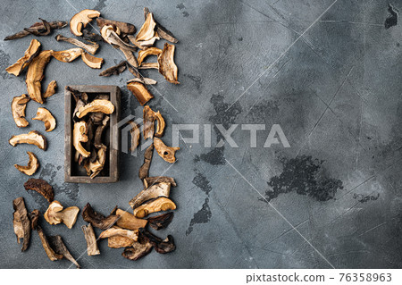Dried wild mushrooms, on gray background, top view flat lay , with space for text copyspace Dried wild mushrooms, on gray background, top view flat lay , with space for text copyspace 76358963