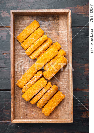 Frozen fish Sticks , in wooden box, on old dark wooden table background, top view flat lay Frozen fish Sticks , in wooden box, on old dark wooden table background, top view flat lay 76358987