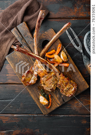 Traditional, roasted rack of lamb cutlets, on wooden serving board, on old dark wooden table background, top view flat lay 76359061