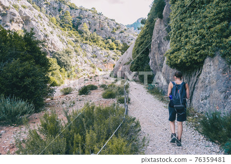 woman hiking on a mountain path in catalonia woman hiking on a mountain path in catalonia 76359481