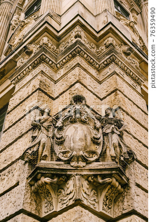 Gothic art in the form of high relief with figures of women and a lion's face on the wall of an ancient building Gothic art in the form of high relief with figures of women and a lion's face on the wall of an ancient building 76359490