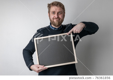 man with beard pointing on blank blackboard 76361856