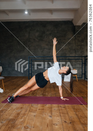 Beautiful young woman practising yoga at home. Beautiful young woman practising yoga at home. 76362864