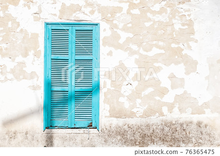 Wooden Turquoise window shutters on a grunge wall 76365475