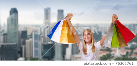 Shopping woman holding shopping bags above her head smiling during sale shopping over city background Shopping woman holding shopping bags above her head smiling during sale shopping over city background 76365761