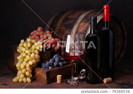 Wine bottles, grapes, glass of red wine and old barrel Wine bottles, grapes, glass of red wine and old barrel 76368538