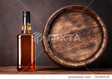Scotch whiskey bottle and old barrel 76368539