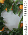 Clementines tangerines and twig with green leaves as spring decor on gray paper 76368994