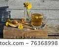 Medicinal Tea from dandelion in  glass cup with honey dandelion against a blue rustic wooden wall  with copy space 76368998