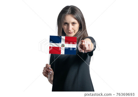 Happy young white woman holding flag of Dominican Republic and points forward in front of him isolated on a white background Happy young white woman holding flag of Dominican Republic and points forward in front of him isolated on a white background 76369693