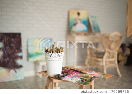 artists brushes and oil paints on wooden palette. 76369726