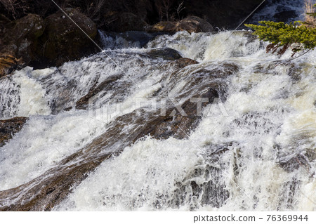 衝破岩石的龍珠瀑布的猛烈流動 76369944