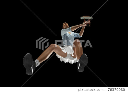 Female professional tennis player in action, motion isolated on black background, look from the bottom. Concept of sport, movement, energy and dynamic. 76370080