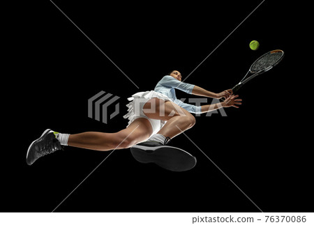 Female professional tennis player in action, motion isolated on black background, look from the bottom. Concept of sport, movement, energy and dynamic. Female professional tennis player in action, motion isolated on black background, look from the bottom. Concept of sport, movement, energy and dynamic. 76370086