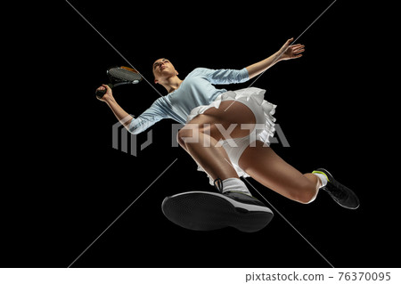 Female professional tennis player in action, motion isolated on black background, look from the bottom. Concept of sport, movement, energy and dynamic. Female professional tennis player in action, motion isolated on black background, look from the bottom. Concept of sport, movement, energy and dynamic. 76370095