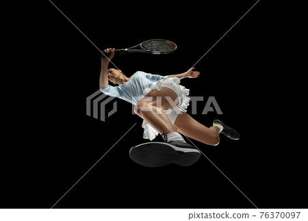 Female professional tennis player in action, motion isolated on black background, look from the bottom. Concept of sport, movement, energy and dynamic. 76370097