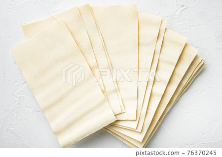Organic lasagna pasta sheets, on white stone background, top view, flat lay 76370245