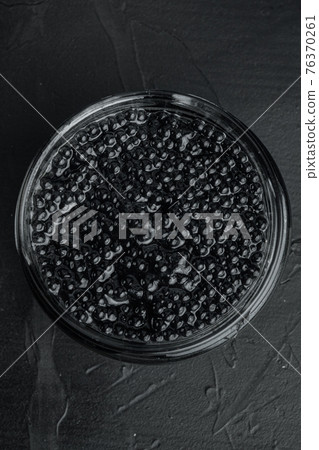 Black sturgeon caviar, on black background, top view flat lay Black sturgeon caviar, on black background, top view flat lay 76370261