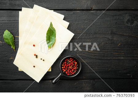 Lasagna dough sheets, with seasoning and herb, on black wooden table background, top view, flat lay, with copy space for text 76370393