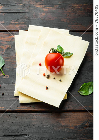 Lasagna dough sheets, with seasoning and herb, on old dark wooden table background 76370405