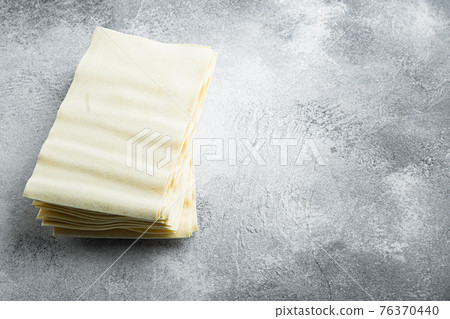 Uncooked lasagna sheets, on gray stone background, with copy space for text 76370440