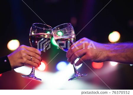 Cheerful couple clinking glasses of champagne at the party. Cheerful couple clinking glasses of champagne at the party. 76370552