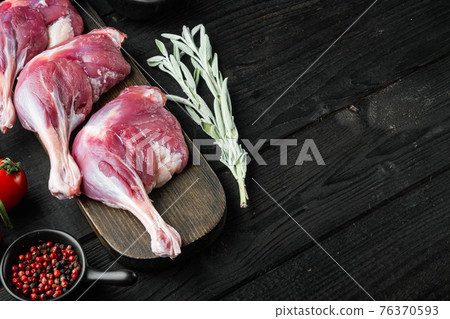 Raw duck leg thighs, with herbs and ingredients, on black wooden table background, with copyspace and space for text Raw duck leg thighs, with herbs and ingredients, on black wooden table background, with copyspace and space for text 76370593
