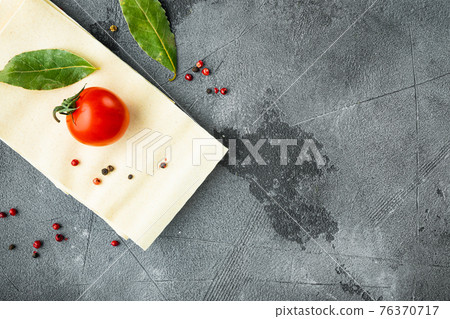 Organic lasagna pasta sheets, with seasoning and herb, on gray stone background, top view, flat lay, with copy space for text 76370717