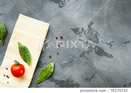 Lasagna dough sheets, with seasoning and herb, on gray stone background, top view, flat lay, with copy space for text 76370742