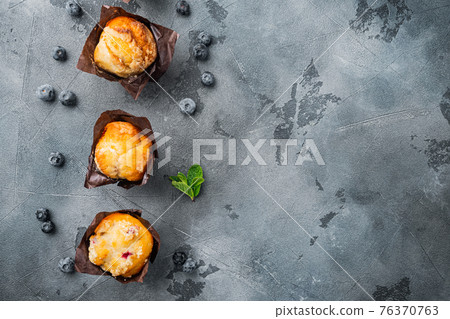 Muffin with blueberries, on gray background, top view flat lay with copy space for text 76370763