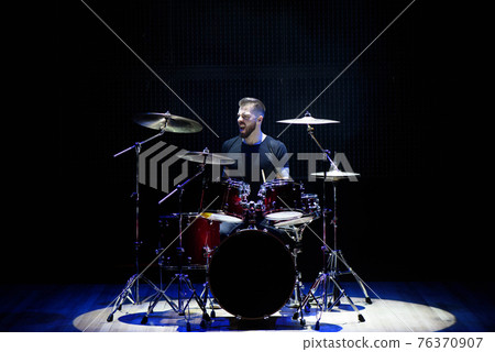 Silhouette drummer on stage. Dark background, smoke spotlights. Silhouette drummer on stage. Dark background, smoke spotlights. 76370907