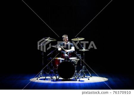 Drummer playing the drums with smoke and powder in the background. Drummer playing the drums with smoke and powder in the background. 76370910