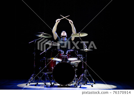 Drummer playing the drums with smoke and powder in the background. Drummer playing the drums with smoke and powder in the background. 76370914