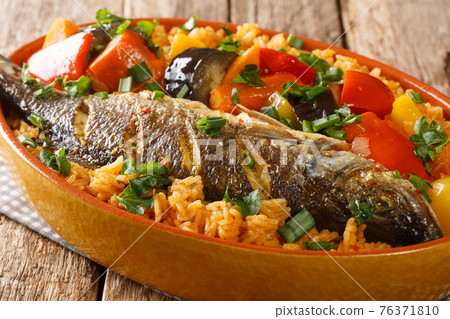 Senegalese Thieboudienne it is a preparation of fresh fish, and rice, cooked with vegetables such as cassava, pumpkin, cabbage, carrot, eggplant closeup. horizontal Senegalese Thieboudienne it is a preparation of fresh fish, and rice, cooked with vegetables such as cassava, pumpkin, cabbage, carrot, eggplant closeup. horizontal 76371810